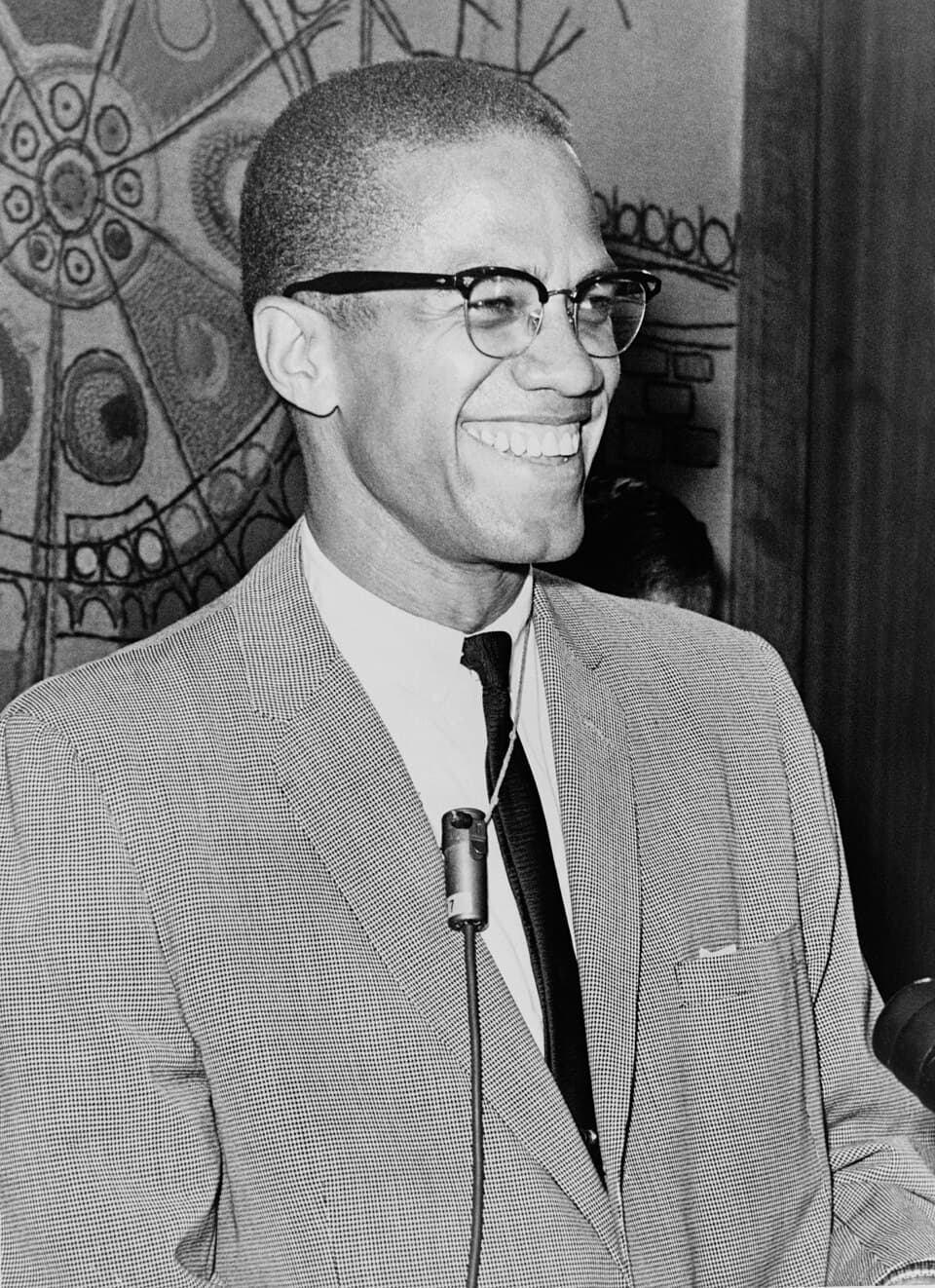 Archival press photograph of Malcolm X smiling